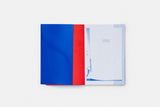 Open publication 'Ministry of Loneliness', the turned page to the left is blue and red and the page to the right is white. The image of the publication is taken on a white background.