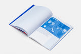 Angled open image of the publication 'Ministry of Loneliness', the page to the left is white and the page to the right illustrates an image of different exposure tones in a blue colour and there is a series of text below the image. The image of the publication is taken on a white background.